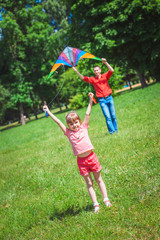 The girl and her father play with a kite.