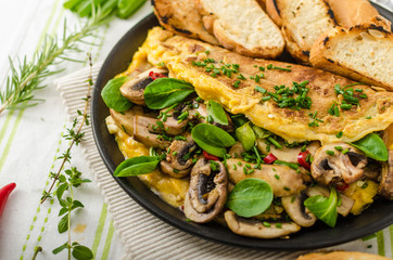 Omelet with mushrooms, lamb's lettuce, herbs and chilli