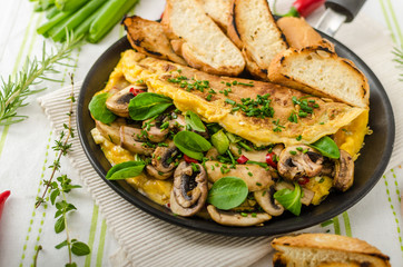 Omelet with mushrooms, lamb's lettuce, herbs and chilli
