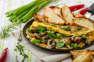 Omelet with mushrooms, lamb's lettuce, herbs and chilli