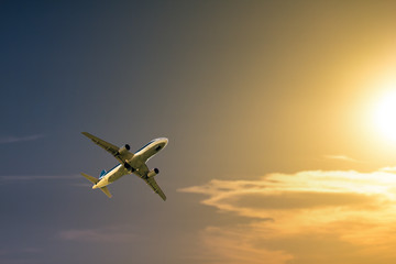 Fototapeta na wymiar A plane flying towards a beautiful sunset