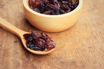 Heap of raisins on wood background