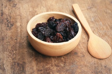 Heap of raisins on wood background