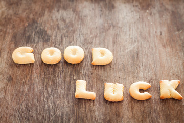 Good luck alphabet biscuit on wooden table