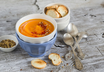 pumpkin soup in ceramic bowls on a light wooden background
