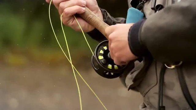 Man Reeling in a Fish from a River
