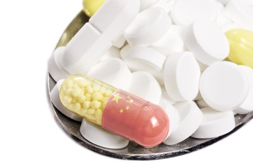 Spoon full of pills and a capsule with the flagdesign of China.(