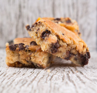 Sweet Brownie Dessert Bar With Chocolate Chips Over Wooden Background