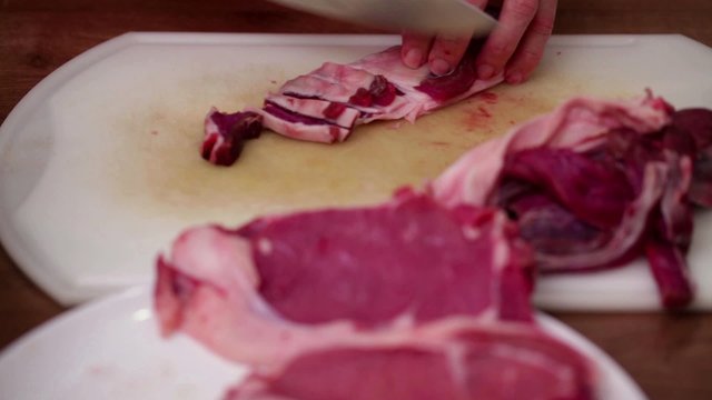 Chef chopping beef and lard onto small chunks using sharp chef knife