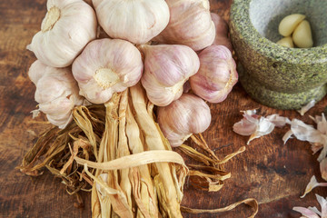 Garlic organic and mortar on wooden background