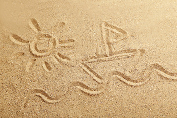 Drawing sun and ship on beach sand