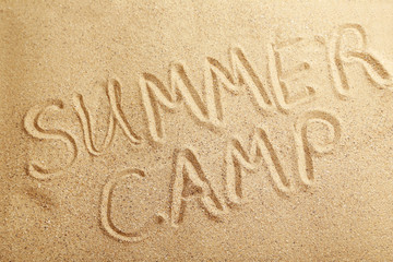 Summer camp handwritten in a beach sand