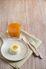 Hokkaido cheesecake with fruit juice with wooden background