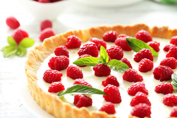Sweet tart cake with raspberries on white wooden background