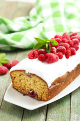 Raspberry cake on plate on green wooden background