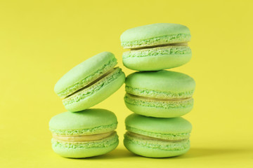 Green macarons on yellow paper background