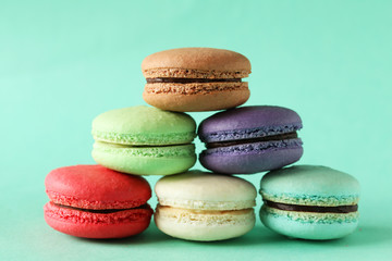 French colorful macarons on green background