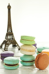 French colorful macarons on white wooden background, close up