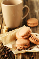 Coffee macarons with coffee beans on brown wooden background
