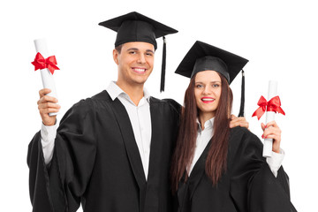 Young couple posing with their diplomas