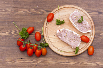 Fresh Raw Steak Meat with spaces, herbs and vegetables on wooden board, selective focus