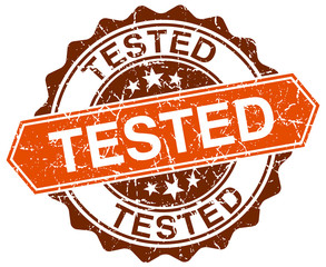 tested orange round grunge stamp on white