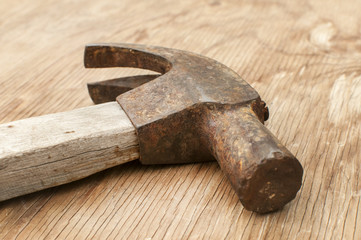 Old weathered grunge hammer adze head closeup on plywood surface