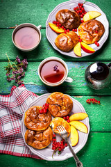 Fritters and tew on wooden table.