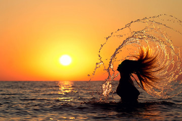 silhouette of a beautiful girl diving into the sea
