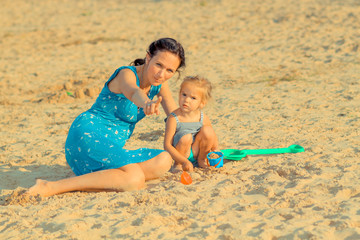 Mother with children playing with sand on beach