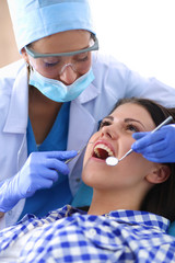 Woman dentist working at her patient&amp;amp;amp;#39;s teeth