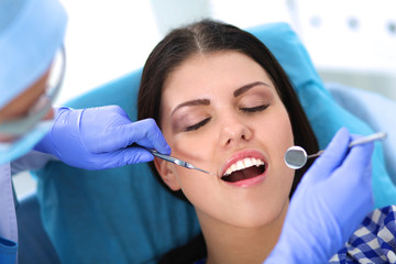Fototapeta premium Woman dentist working at her patient&amp;amp;#39;s teeth