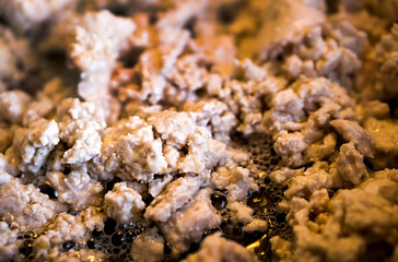 Fresh minced meat fried in pan with oil