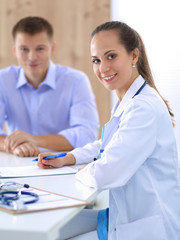 Fototapeta premium Doctor woman sitting with male patient at the desk