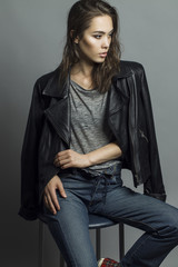 Portrait of a fashionable model with natural make up and perfect  skin, dressed in men's jeans,...