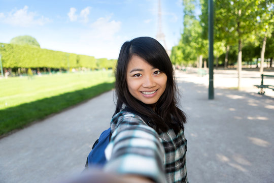 Young attractive asian tourist in Paris taking selfie