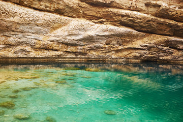 Sinkhole with emerald green water at Hawiyat Najm Park, Oman