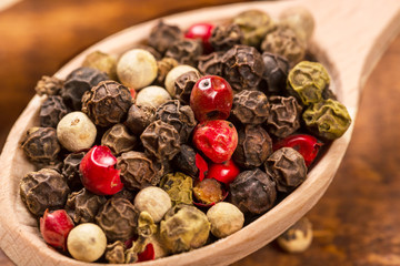 Pepper seeds in wooden spoon on wood table