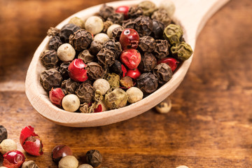 Pepper seeds in wooden spoon on wood table