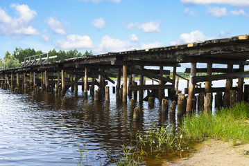 Fototapeta premium Old wooden bridge over the river, Russia