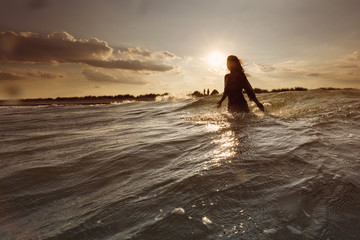 Young woman on sea embracing the the world and the waves