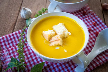 Pumpkin soup with croutons in white bowl