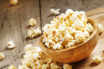 Sweet caramel popcorn in a wooden bowl, selective focus