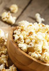 Sweet caramel popcorn in a wooden bowl, selective focus