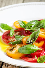 Vegetable salad of colorful tomatoes and basil with olive oil an