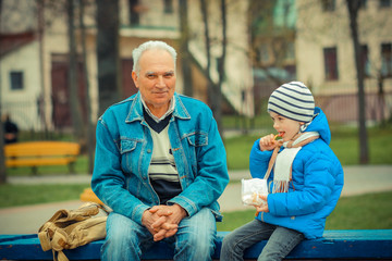 Grandfather and grandson eating fries and indulge