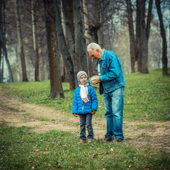 Naklejka na ściany i meble Grandfather showing grandson vintage watches. The grandfather tells his grandson about time.
