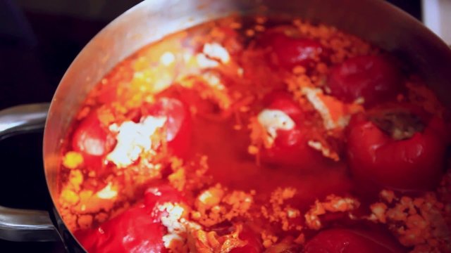 Hand chef opens a pot with pepper stuffed