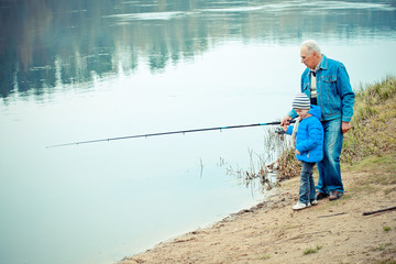 Grandfather and grandson are fishing