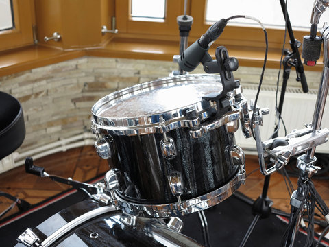 Black drum kit, cables and microphones closeup